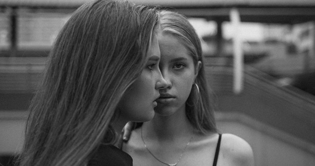 2 teen girls, one looking at camera, the other profile.